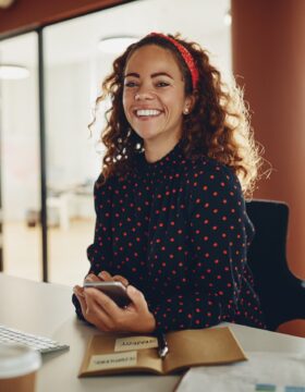 smiling-young-businesswoman-using-a-cellphone-at-h-2023-11-27-05-12-36-utc (1)